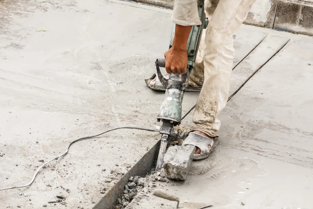 Core drilling machine making circular holes in wet concrete.